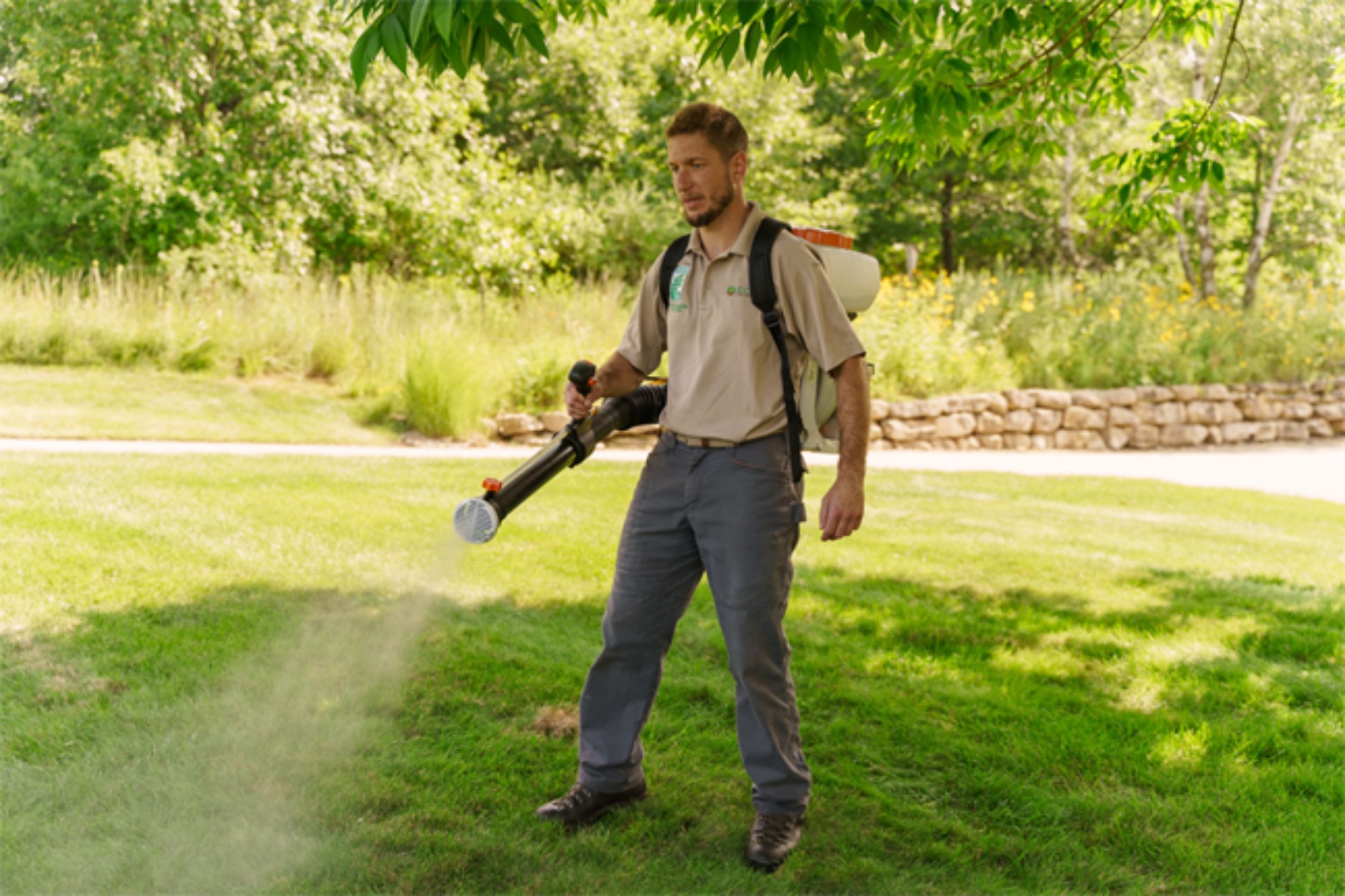 Worker using organic spray for mosquito treatment